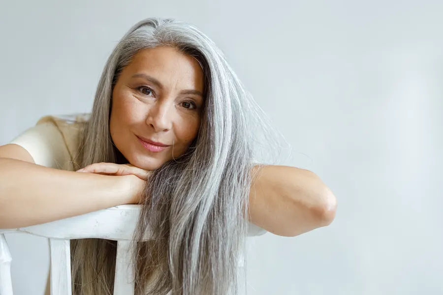 An attractive woman resting head on hands on chair