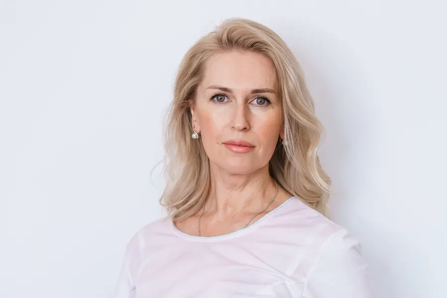 A blonde woman posing in a studio headshot