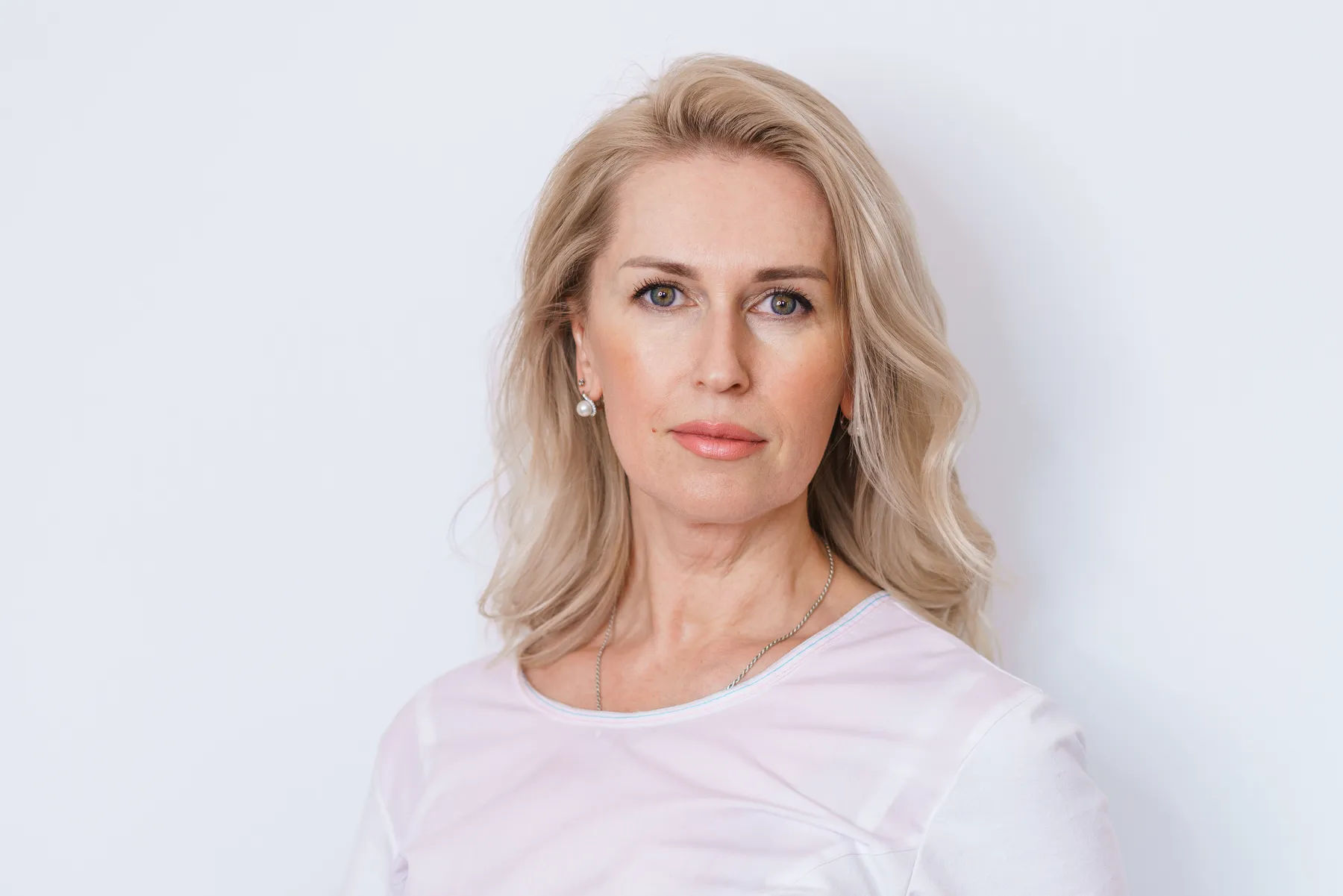 A blonde woman posing in a studio headshot