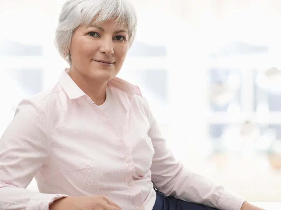 A confident woman poses in natural light indoors