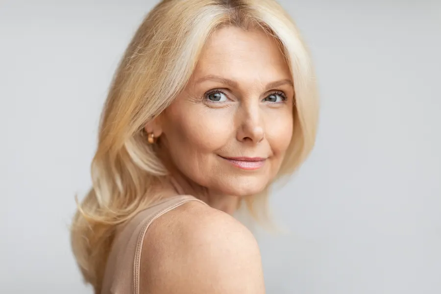 An elegant woman with wavy blonde hair posing