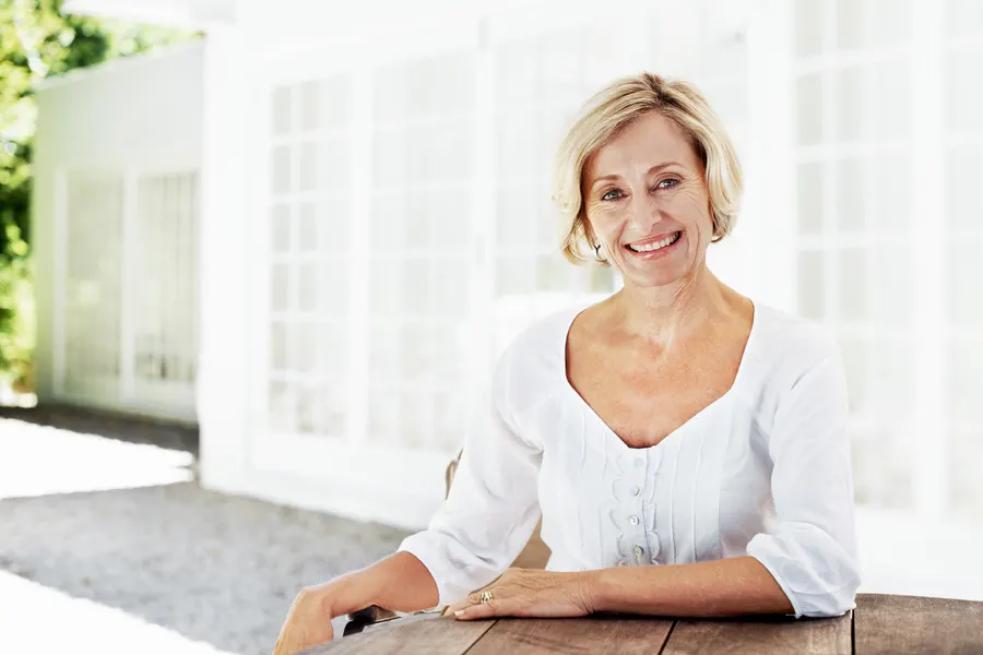 A radiant senior woman smiling outdoors on a sunny