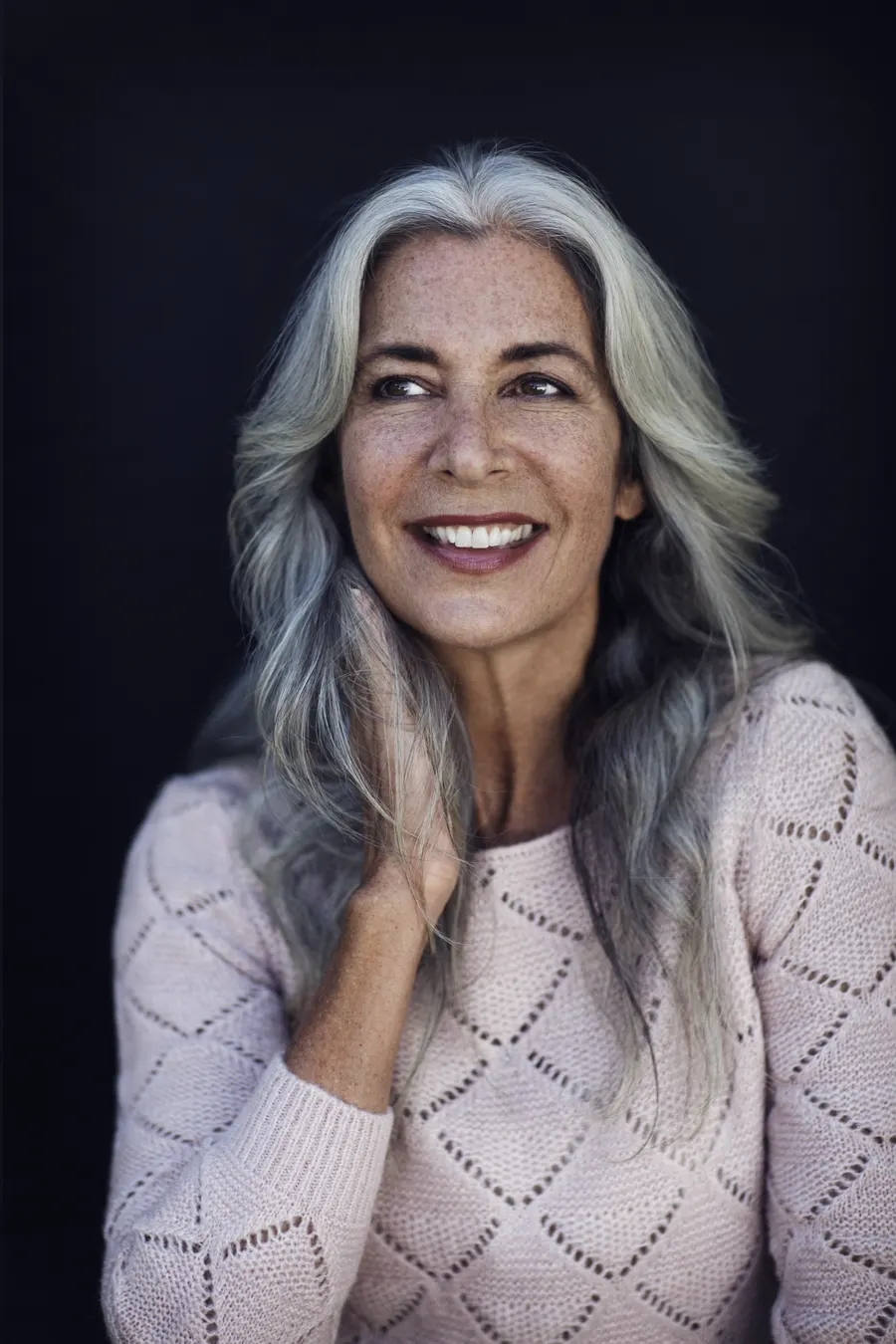 A radiant senior woman with long grey hair smiling