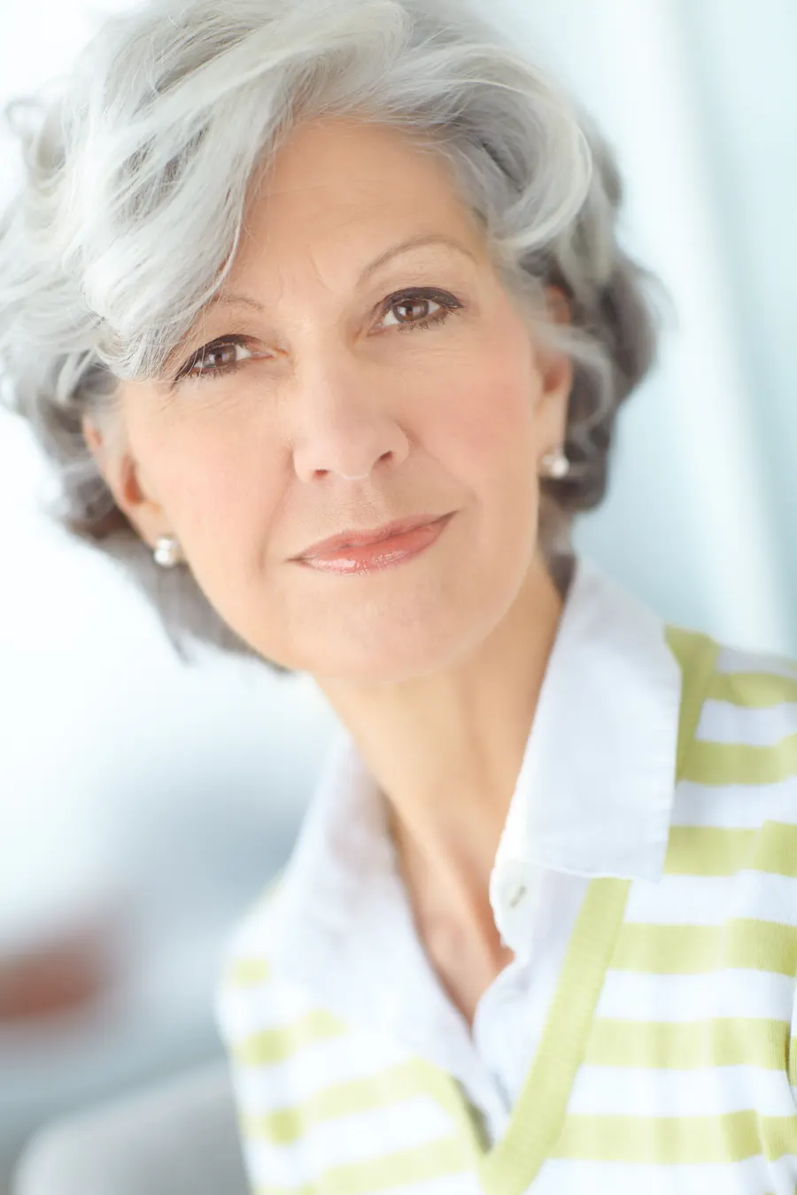 A senior woman smiling and posing indoors