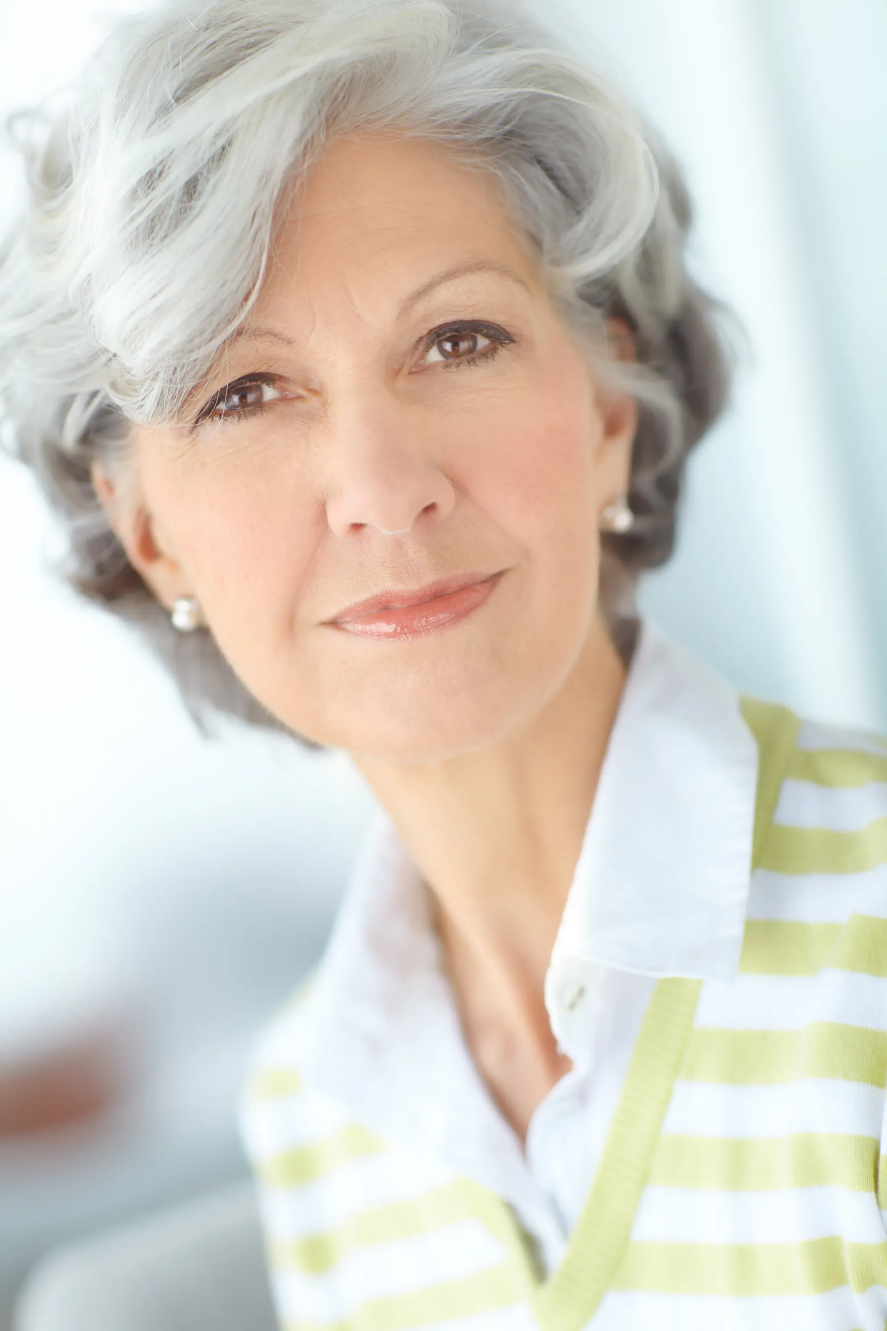 A senior woman smiling and posing indoors