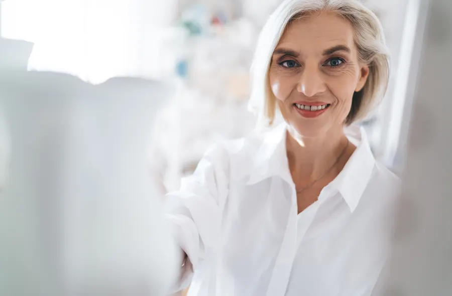 A smiling senior woman in white shirt indoors