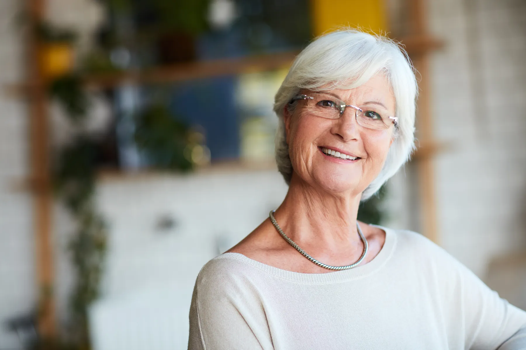 A smiling senior woman portrait in a bright home