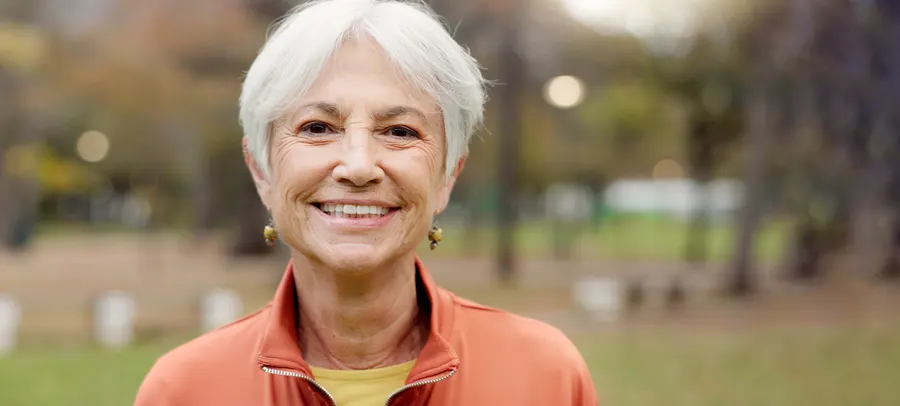 A smiling senior woman portrait outdoors in natural