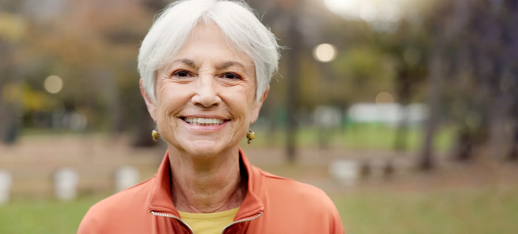 A smiling senior woman portrait outdoors in natural