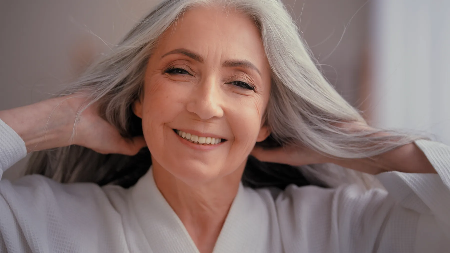 A smiling senior woman posing in comfortable robe