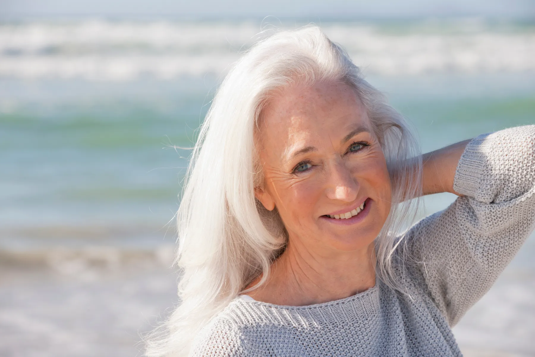 A smiling senior woman posing on the beach