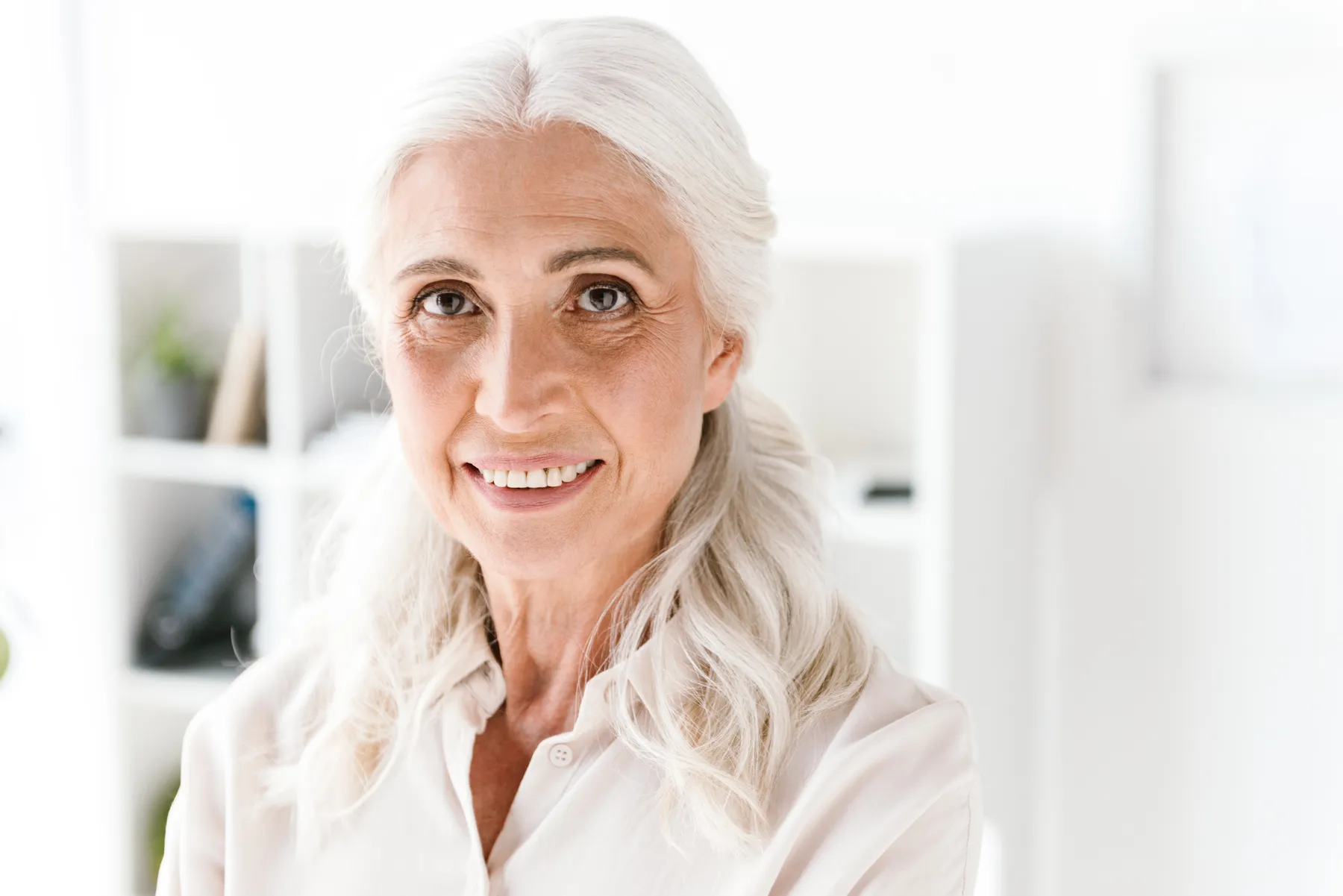 A smiling senior woman s waist up portrait indoors