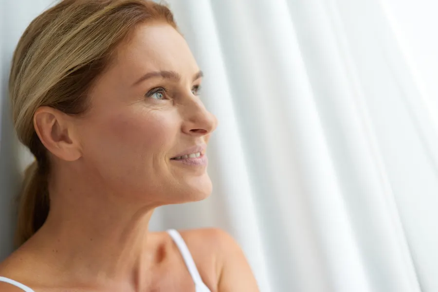 A smiling woman relaxing at home in soft light
