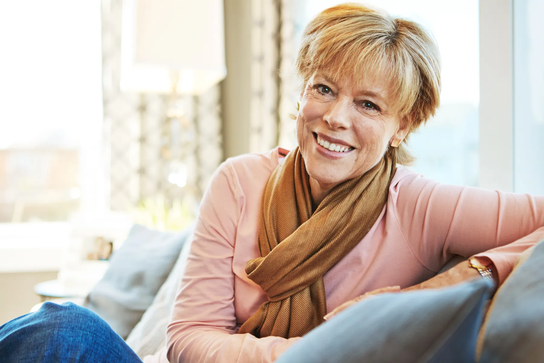 A smiling woman relaxing on sofa at home