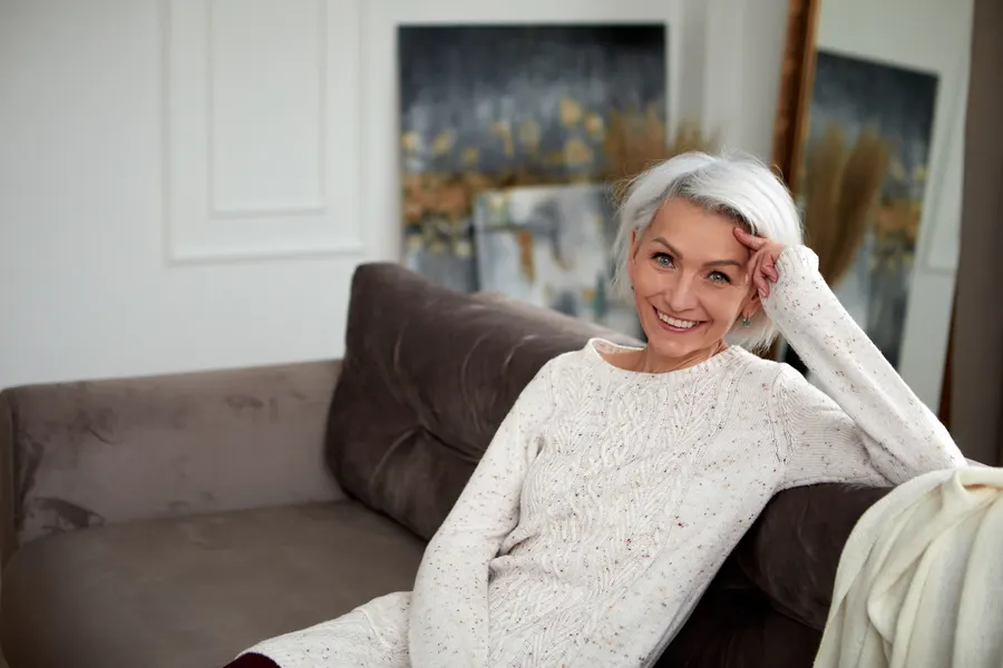 A smiling woman relaxing on sofa in living room