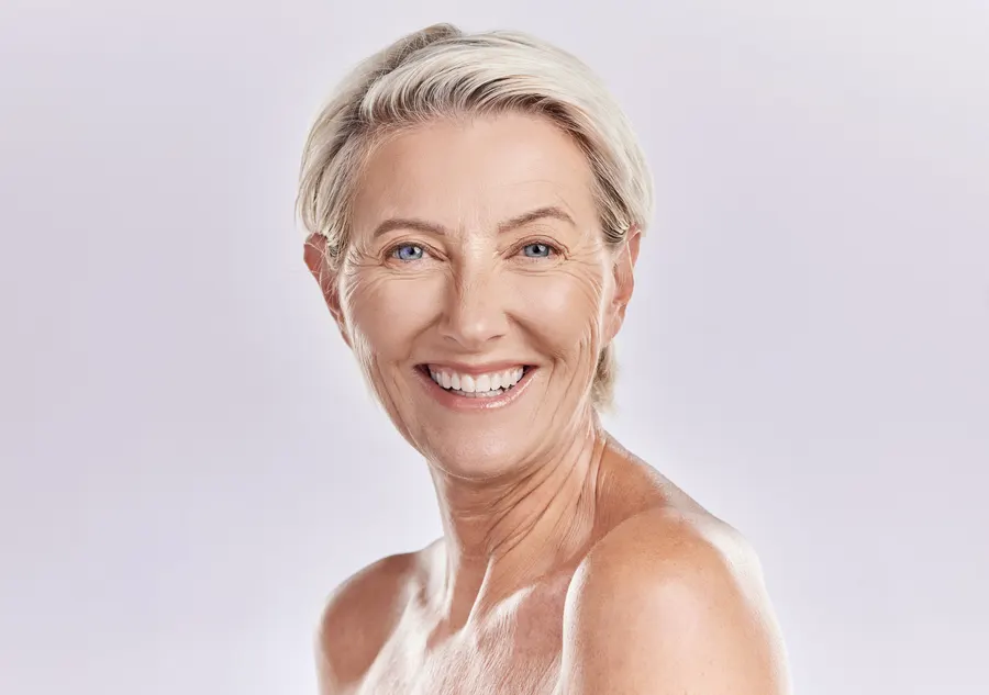 A smiling woman shows radiant skin in headshot