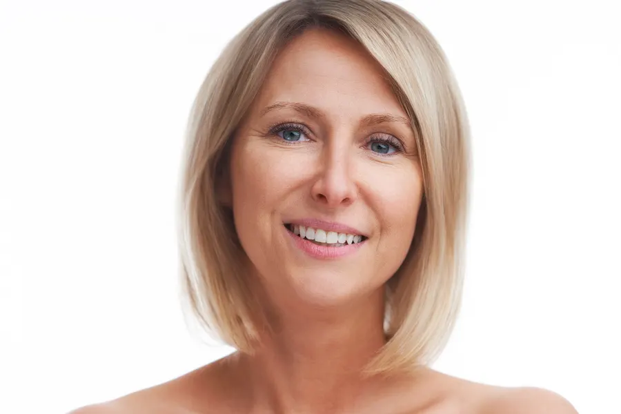 A smiling woman with blonde bob hairstyle posing