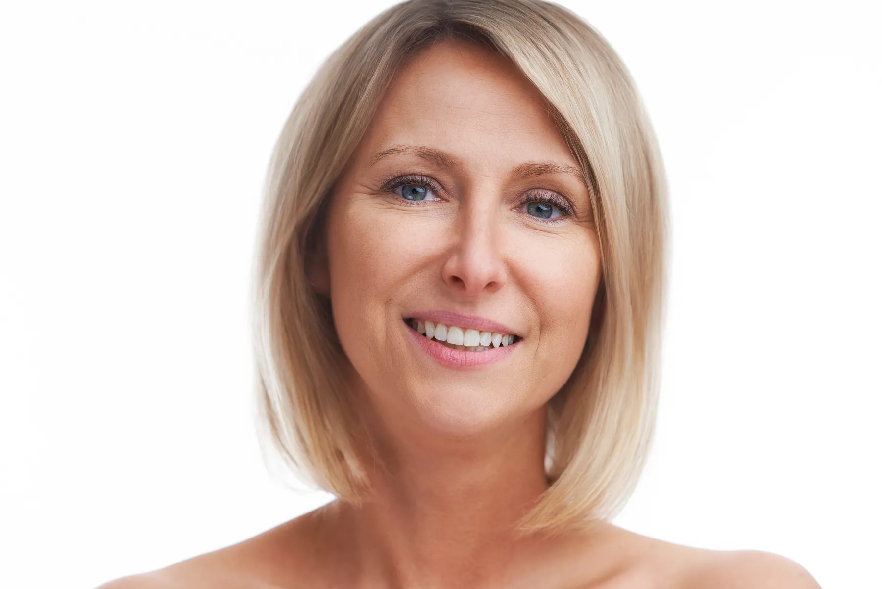 A smiling woman with blonde bob hairstyle posing