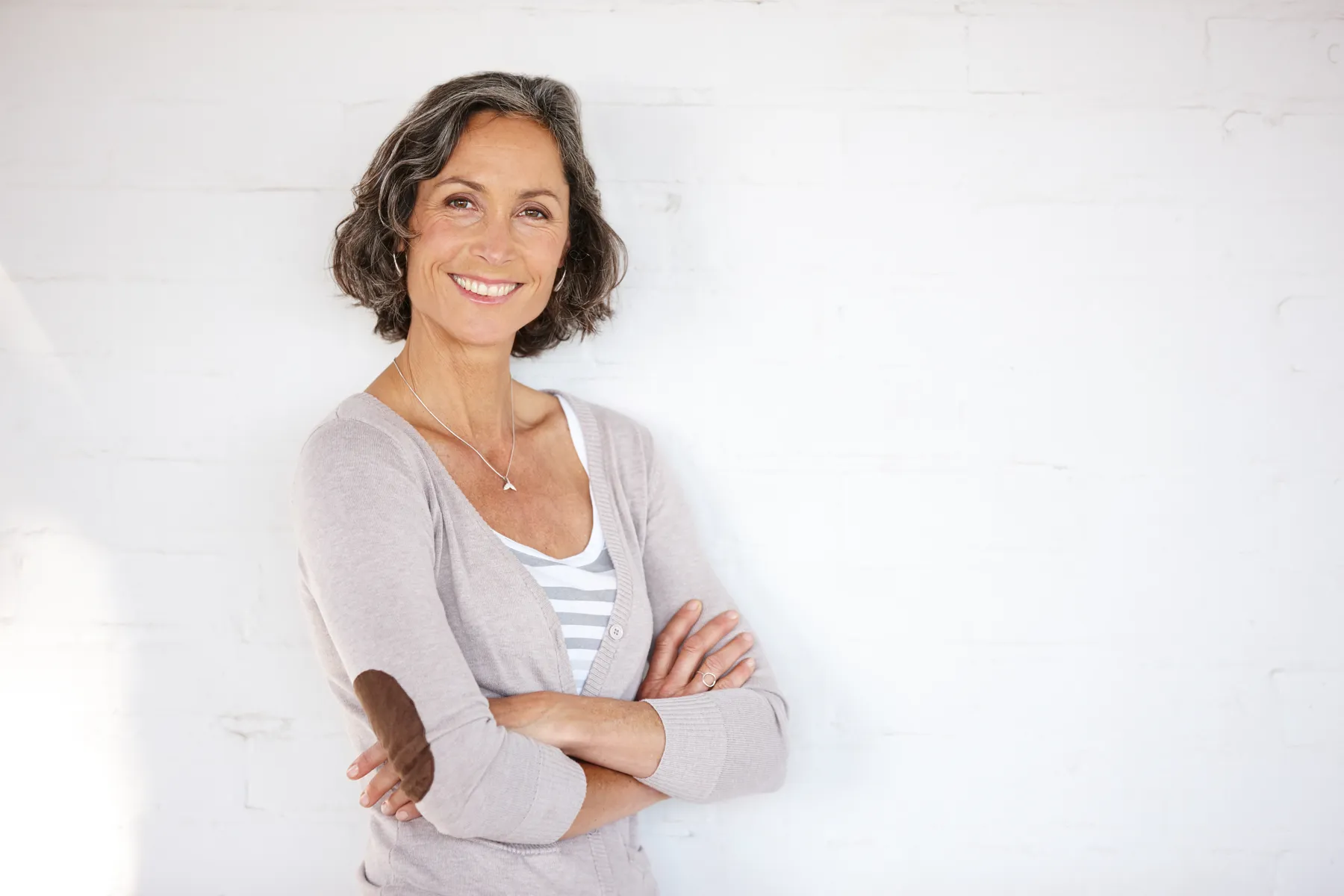A smiling woman with gray hair and cardigan