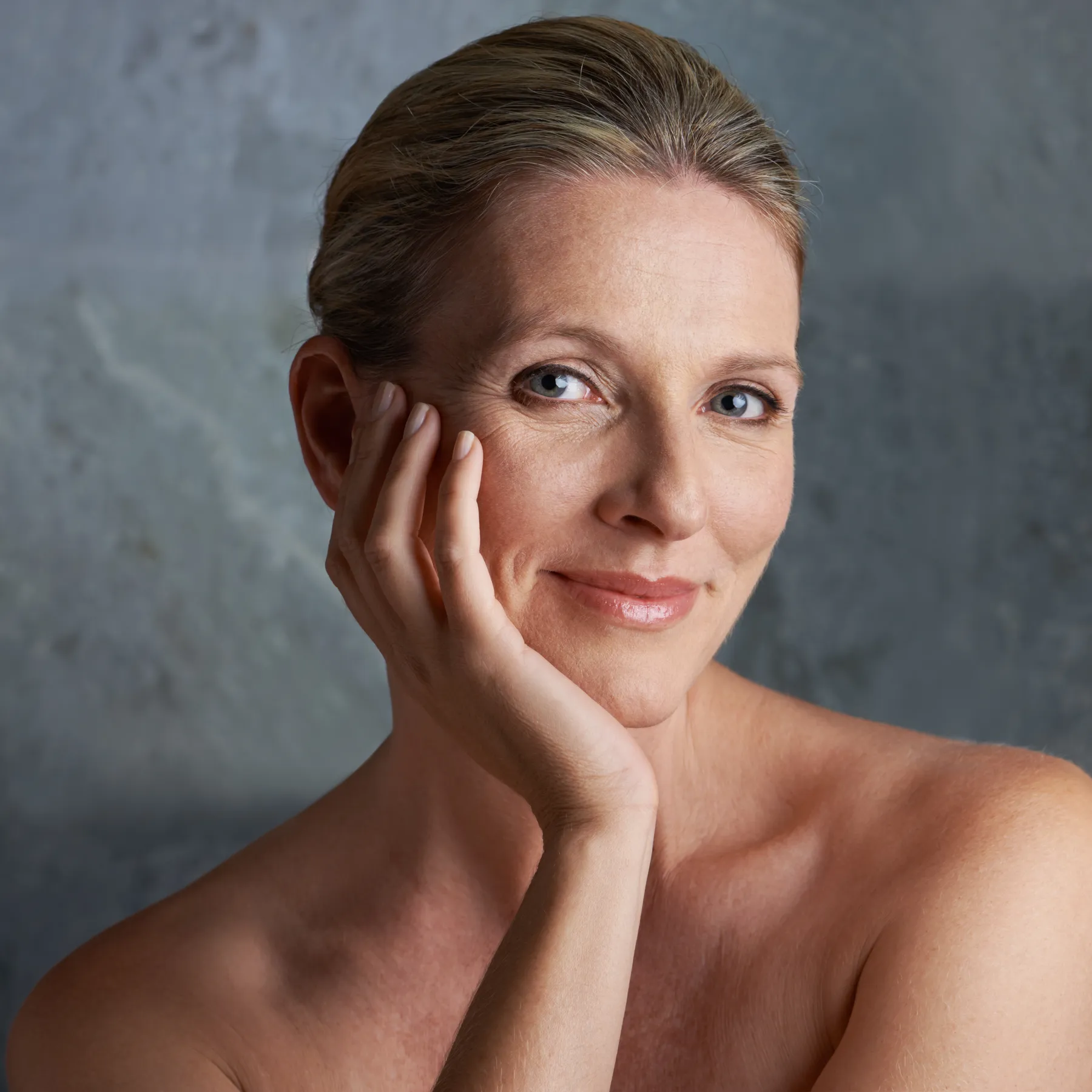 A smiling woman with hand to face posing