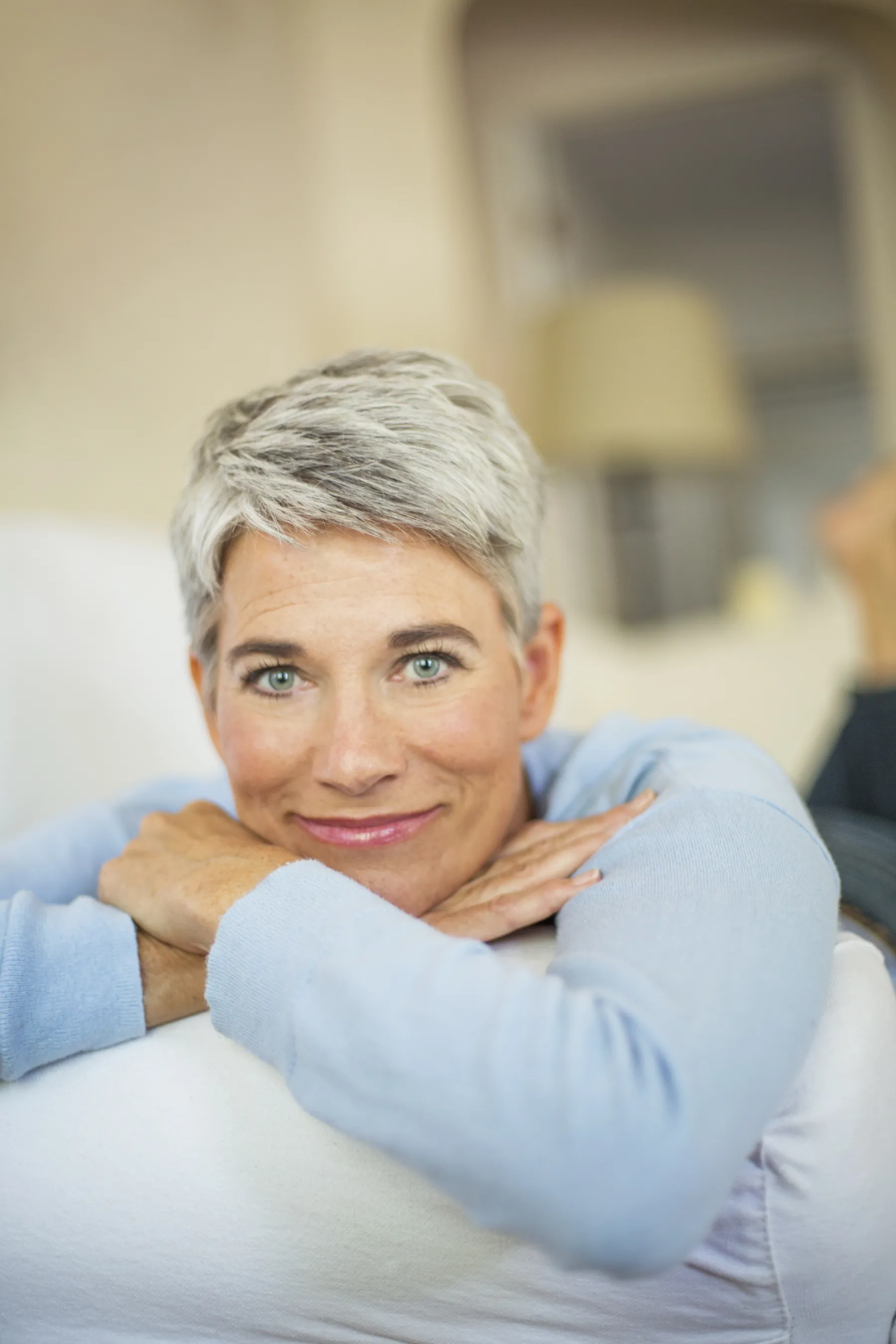 A smiling woman with short gray hair indoors