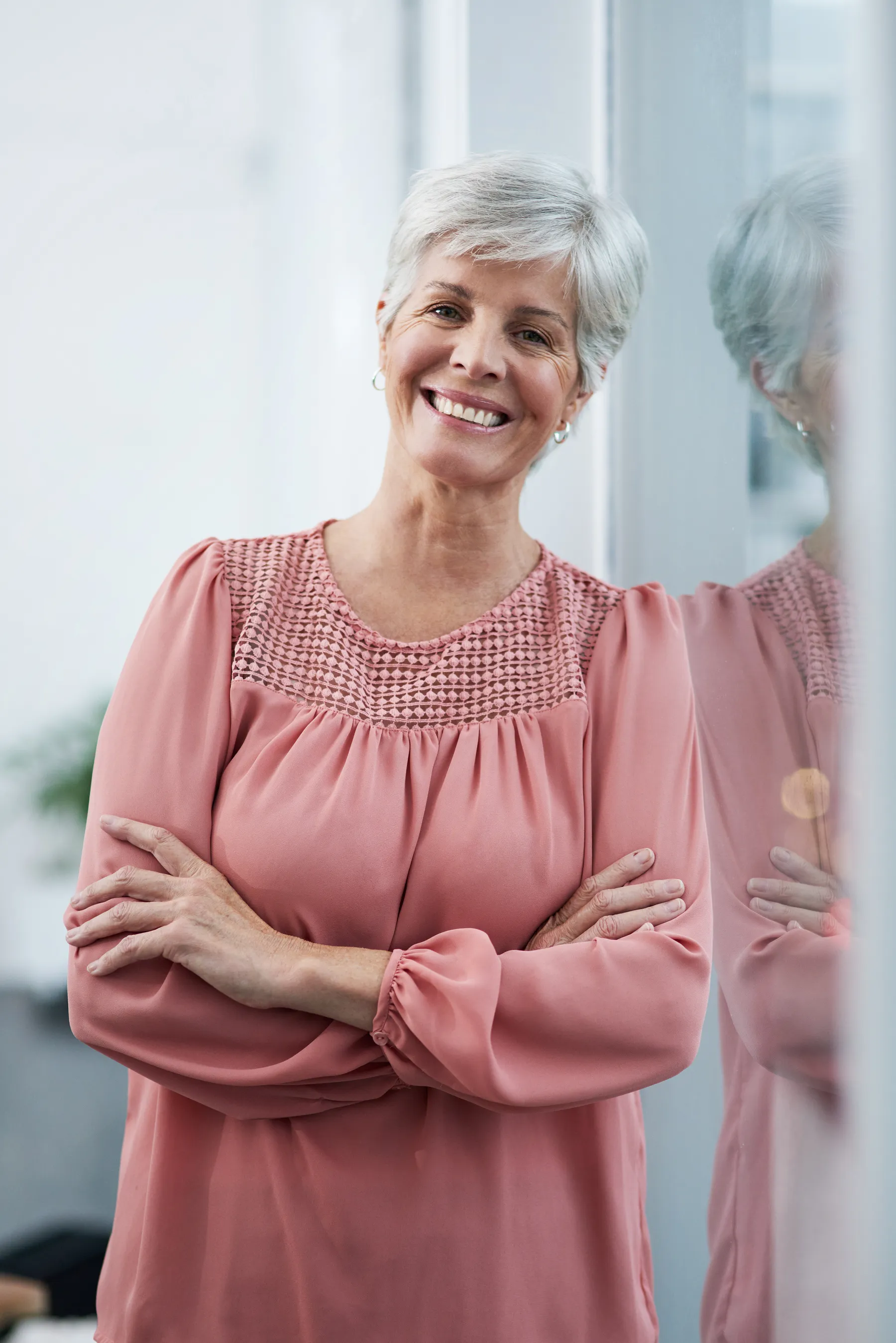 A smiling woman with short gray hair posing indoors