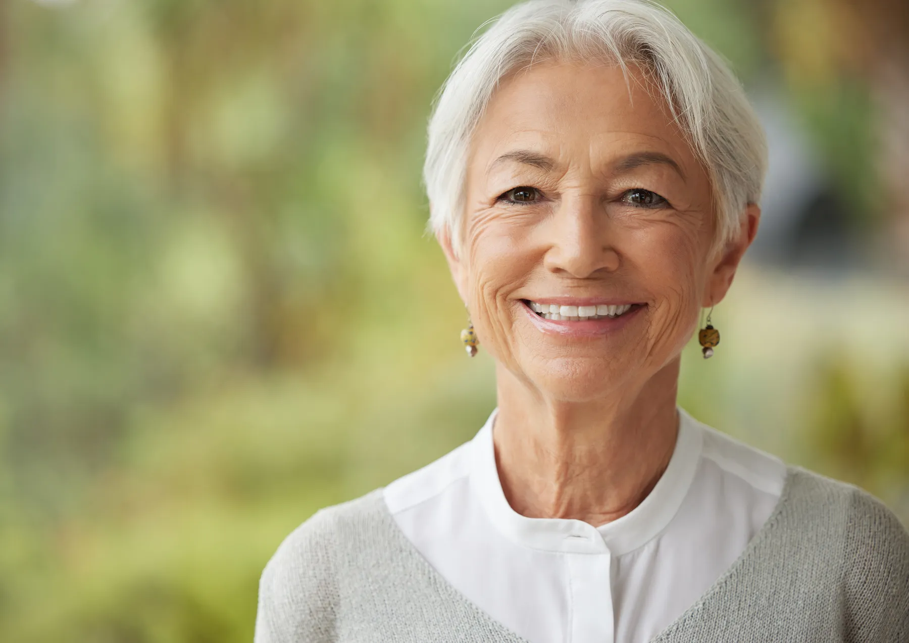 A smiling woman with short gray hair posing