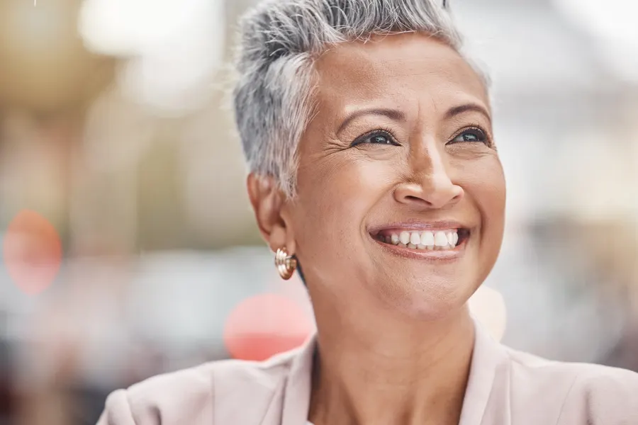 A smiling woman with short grey hair outdoors