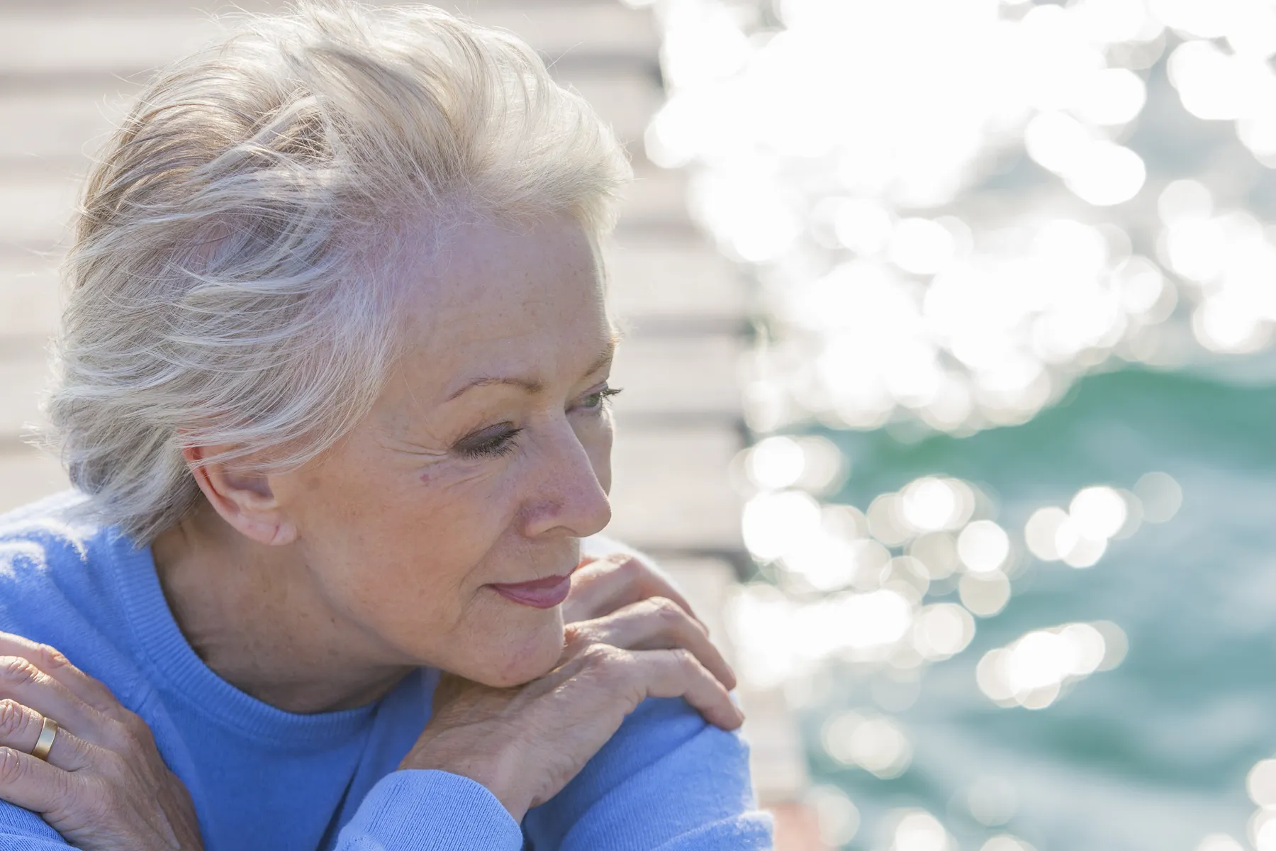 A thoughtful senior woman with grey hair at beach