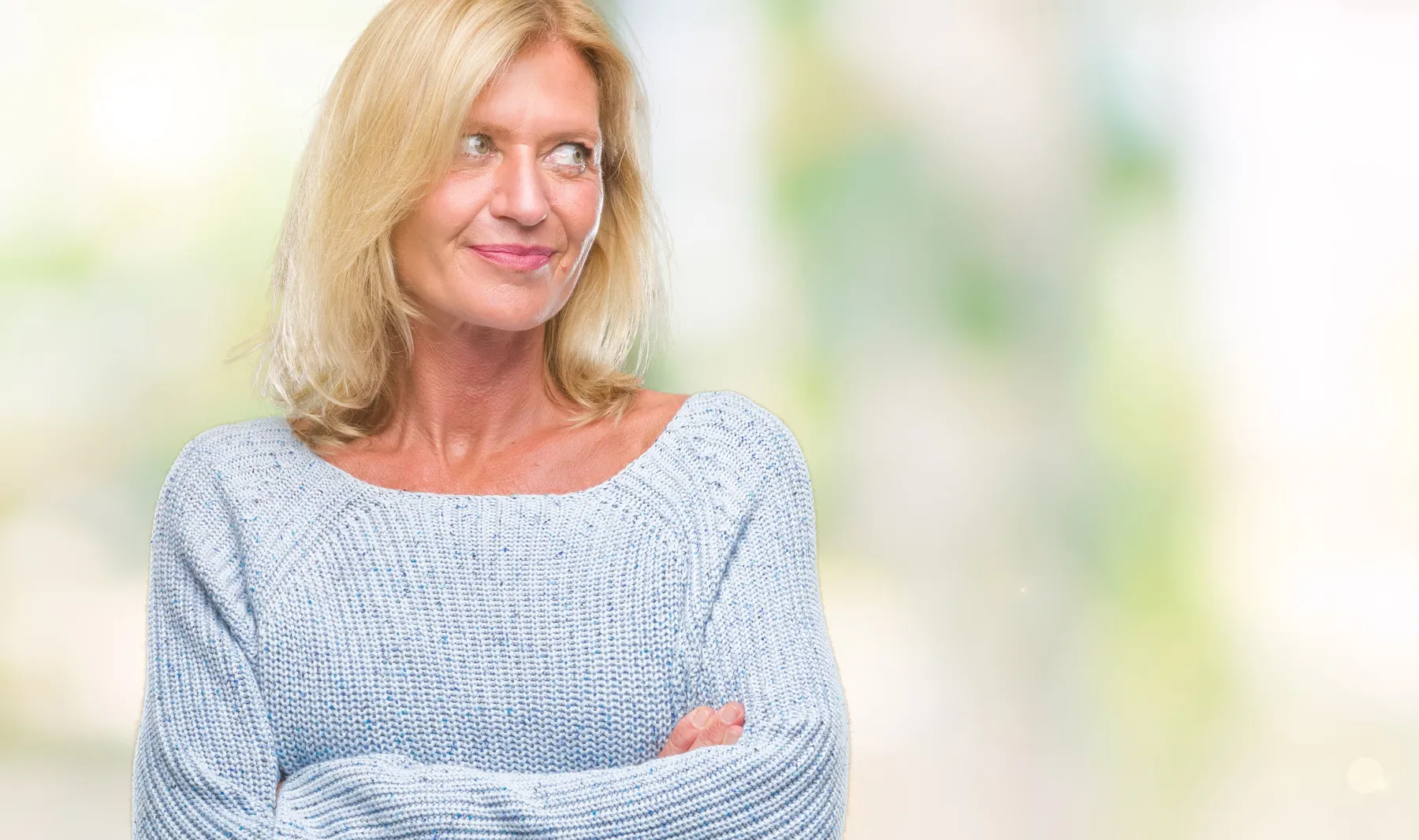 A woman in blue sweater looking away thoughtfully