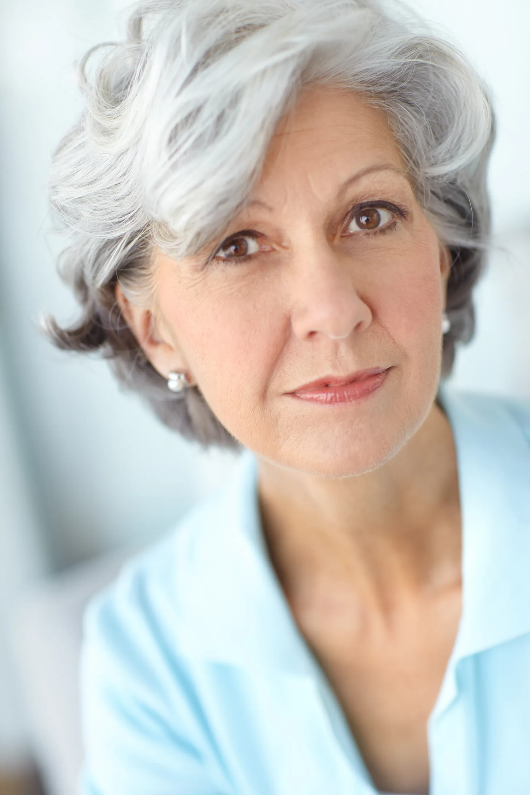 A woman smiling calmly in a light blue shirt