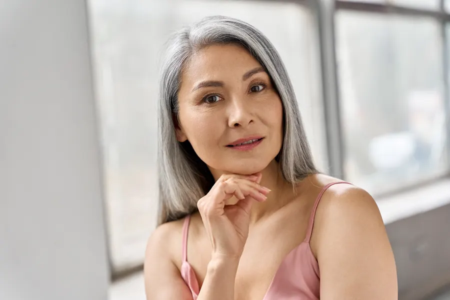 A woman with gray hair posing indoors