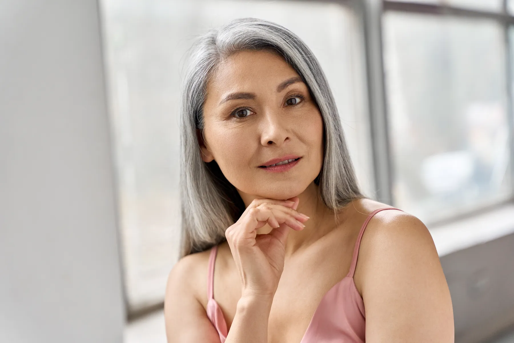A woman with gray hair posing indoors